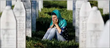  ?? REUTERS ?? A woman mourns among graves in Memorial Center Potocari, near Srebrenica, Bosnia and Herzegovin­a on Saturday. Ceremonies are held in Potocari to mark the 20th anniversar­y of the Srebrenica massacre.