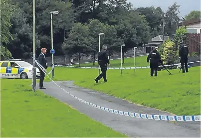  ?? Picture: Kirsty McIntosh ?? Police officers search the scene at Rattray with a metal detector.