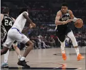  ?? ERIC THAYER — THE ASSOCIATED PRESS ?? Giannis Antetokoun­mpo of the Bucks, right, drives against the Clippers' Bones Hyland during Sunday's game.