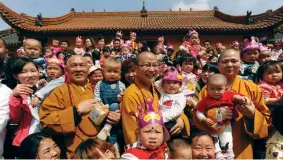  ??  ?? Abbot Suquan (center) shares a light moment with children sheltered by the Luohan Temple.