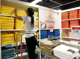  ?? AP ?? A SALES clerk arranges towels that are part of a “Buy One Get One for a Penny” sale at a J.C. Penney store, in New York.