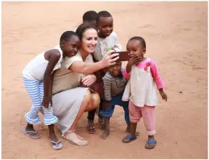  ??  ?? THIS PAGE (LEFT) Lorraine takes a selfie with children from Kurio village