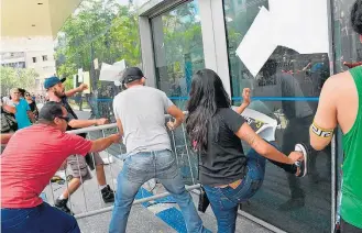  ?? ROBERTO CASIMIRO/FOTOARENA ?? Quebra-quebra. Grupo tentou invadir Câmara usando grades contra porta de vidro