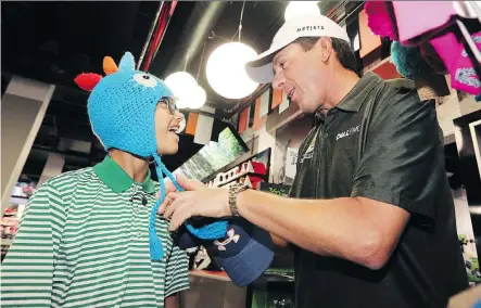  ?? GAVIN YOUNG ?? Logan McLean, 13, tried on some goofy hats with PGA golfer Billy Andrade at Sport Chek during a back-to-school shopping spree Tuesday.
