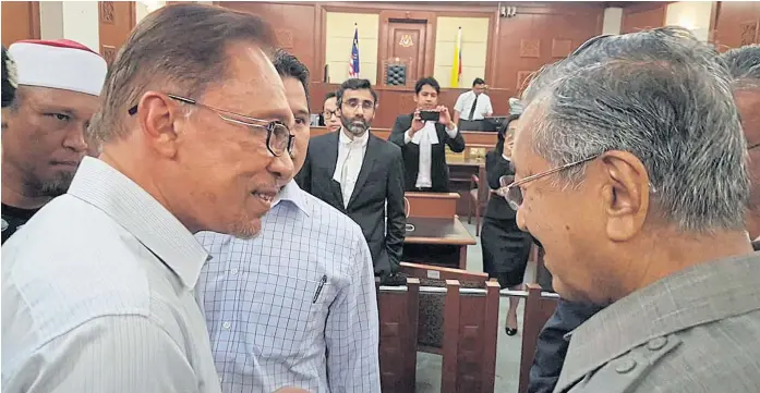  ??  ?? BACK IN THE FRAY: Malaysia’s former prime minister Mahathir Mohamad, right, meets jailed opposition leader Anwar Ibrahim in a high court in Kuala Lumpur in September 2016.