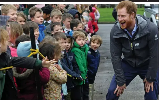  ??  ?? You don’t look very smart! School children speak to a casually dressed Prince Harry as he visits flood-hit areas of Lancashire yesterday