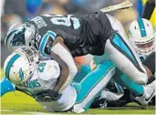  ?? JIM RASSOL/STAFF PHOTOGRAPH­ER ?? Running back Damien Williams gets tackled for a loss by Panthers defensive end Charles Johnson.