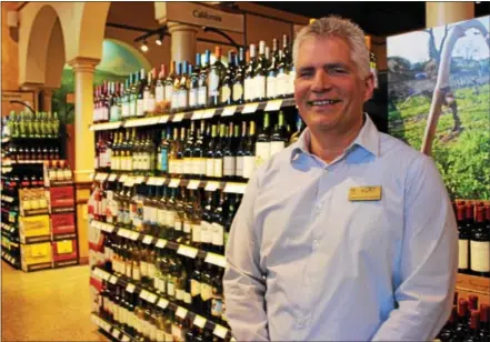  ?? BRIAN MCCULLOUGH — DIGITAL FIRST MEDIA ?? Wegmans Downingtow­n store manager Kurt Husebo stands in front of the new wine offerings. The store began selling wine in the store on Friday.