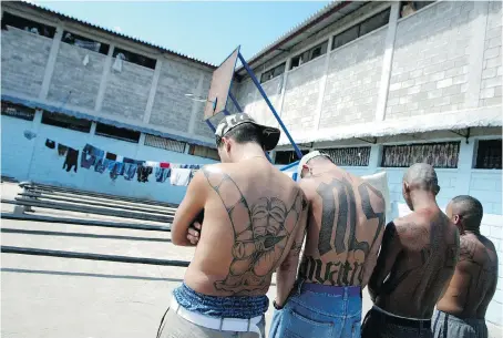  ?? ELMER MARTINEZ/AFP/GETTY IMAGES ?? Four tattooed members of the Mara Salvatruch­a MS-13 juvenile gang are imprisoned in the National Penitentia­ry in Tamara, Honduras. The gang’s American affiliates have allowed women to become members, and they are proving to be just as violent as men.