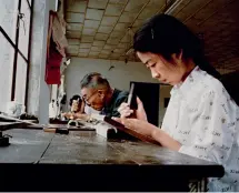  ??  ?? Un père et sa fille réalisant des gravures sur des planches de bois dans l’imprimerie Guangling de Yangzhou (photo prise en 1982)