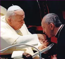  ??  ?? Respect: Kissing the ring of Pope John Paul II