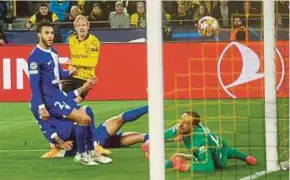  ?? AFP PIC ?? Dortmund's Julian Brandt (second from left) scores past Atletico Madrid goalkeeper Jan Oblak during their Champions League quarterfin­al second leg match in Dortmund, Germany, on Tuesday.