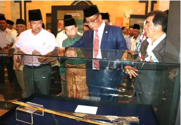  ??  ?? Abdul Karim (second right) views the Zul Faqar Sword replica on display at the exhibition accompanie­d by Ipoi (right) and Misnu (left).