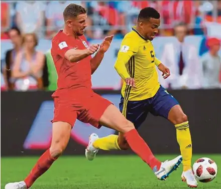  ?? AFP PIC ?? England’s Jordan Henderson (left) vies for the ball with Sweden’s Martin Olsson during their World Cup quarter-final match on Saturday.
