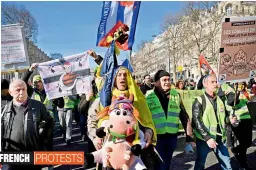  ?? — AFP ?? People walk down Champs- Elysees avenue on Sunday during a yellow vest protest movement against the French President’s policies and other issues.