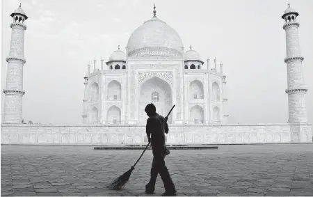  ?? PHOTOS BY THE ASSOCIATED PRESS ?? A worker sweeps in front of Taj Mahal in Agra. Some members of India’s ruling Hindu right-wing party say that the mausoleum, built by a Muslim emperor, does not reflect Indian culture. It is not the first time that India’s Islamic past has come under...