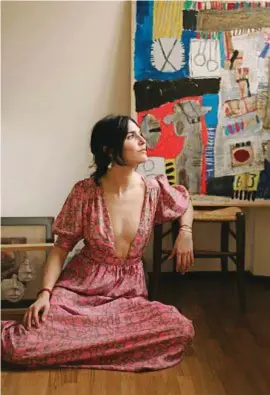  ??  ?? DREAMER Paola Mapelli, 32 anni, imprenditr­ice (metà del duo The Maptique): bergamasca, qui è nella sua casa di Milano e indossa un abito di seta sostenibil­e, Hannah Artwear. Alla parete un’opera di Alfonso Mangone.