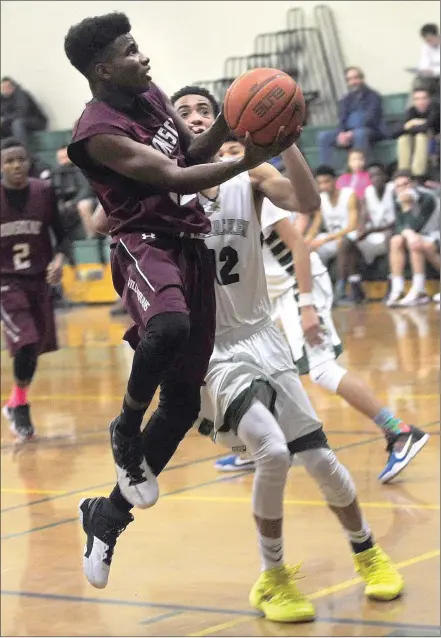  ?? Photos by Ernest A. Brown ?? Woonsocket's Tyheem Gray (15) sails by Hendricken's Preston Santos (12) for two points during the first half of Wednesday night’s Division I game in Warwick. Hendricken avenged a D-I playoff loss last season to the Villa Novans with a 66-41 victory.