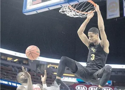  ?? PHELAN M. EBENHACK/ASSOCIATED PRESS ?? UCF’s A.J. Davis delivers a dunk in the 1st half but was plagued by foul trouble in the 2nd half of Friday’s quarterfin­al game with Houston.