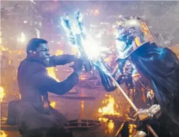  ?? LUCASFILM LTD. ?? Finn (John Boyega), left, engages in a brutal duel with Captain Phasma (Gwendoline Christie) aboard a ruined starship.