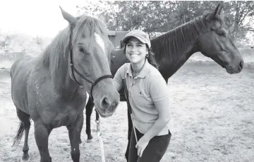  ??  ?? Saudi Dana al-Gosaibi poses with horses during a training session on March 1, 2017, in the Red Sea city of Jeddah.The 35-year-old Saudi horse trainer dreams of opening her own stables to focus on “a more gentle” way of training horses than the standard...