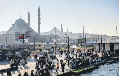  ?? ?? Pedestrian­s walk next to a ferryboat port in the Eminönü district, Istanbul, Türkiye, Feb. 22, 2024.