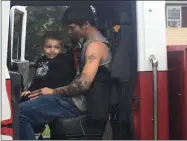  ?? KEVIN MARTIN — THE MORNING JOURNAL ?? Two-year-old Connor Rutledge and father Kory Rutledge get a ride in the Lorain Fire Department Pumper No. 4.