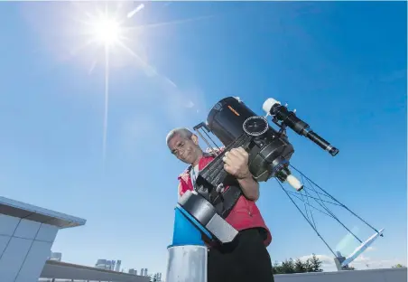  ??  ?? Astronomer Karun Thanjavur sets up a modified telescope — it projects an image of the sun — that will be used for viewing the Aug. 21 solar eclipse from the roof of the Bob Wright Building at the University of Victoria.