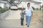  ??  ?? Duana Kirby stops to give her son Jackson some water Thursday while re-enacting the journey he took to get home.