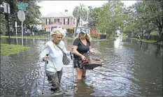  ?? John Raoux/Associated Press ?? Marlene Sulkers, left, is escorted by her granddaugh­ter Rachel Sulkers as they evacuate from Rachel's residence in the aftermath of Hurricane Irma, in Jacksonvil­le, Fla.
