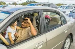  ?? EVE EDELHEIT THE NEW YORK TIMES ?? Victor Lopez-Lucas and his year-old daughter, Kenya, in line to receive food donations in Bradenton, Fla., on Tuesday.