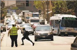  ?? Al Seib Los Angeles Times ?? A TRAFFIC OFFICER directs cars in downtown Los Angeles. One traffic officer made $174,348 on 3,702 hours in overtime last fiscal year, according to a city audit.