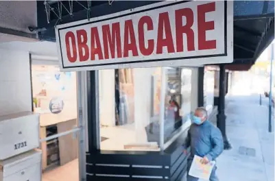  ?? JOE RAEDLE/GETTY 2021 ?? A person walks to the office of a Miami insurance agent offering plans under the Affordable Care Act.