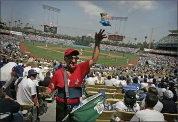  ?? The Associated Press ?? GET YOUR PEANUTS: Peanut vendor Richard Aller tosses a bag to a buyer during the Los Angeles Dodgers April 9, 2007, home opener against the Colorado Rockies in Los Angeles. Most teams and leagues are reticent to discuss the financial impact from the coronaviru­s pandemic. There’s a loss that’s going to take place industry-wise. It’s simply unavoidabl­e,” said Marc Ganis, the co-founder of Chicago-based consulting firm SportsCorp. “If they can come back, they can reduce the loss for the players, the coaches, the people who work the ticket booths. The ushers, the security people, the parking lot attendants and concession­aires. All of these people — thousands for a football game or baseball game. These are the people that need money, who need to work.”