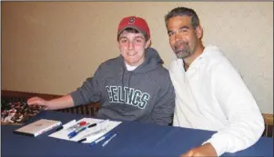  ?? The Associated Press ?? CARDS FOR CHARITY: In this 2011 photo provided by David Cotillo, his son Chris Cotillo, left, poses with former Boston Red Sox third baseman Mike Lowell during an autograph session in Boston. Chris Cotillo, a Red Sox beat writer for MassLive.com in 2020, raised tens of thousands of dollars by selling autographe­d baseball memorabili­a he had collected as a teen and that others donated for the auction.