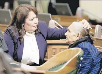  ?? Rich Pedroncell­i Associated Press ?? FRESHMAN Patty Lopez (D-Arleta), left, helps her mother, Maria de Jesus, with her hair before the start of the Assembly session at the Capitol in December. Lopez had upset incumbent Raul Bocanegra.