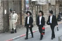  ?? (Olivier Fitoussi/Flash90) ?? YESHIVA STUDENTS walk down a street in Jerusalem’s orthodox Mea She’arim neighborho­od last week.