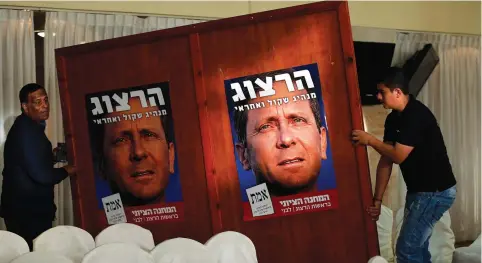  ?? (Reuters) ?? POSTERS OF Isaac Herzog, who heads the center-left Zionist Union coalition, are seen during a conference in Shfaram.