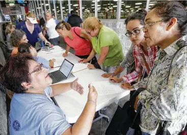  ?? Melissa Phillip photos / Houston Chronicle ?? Volunteer Maria Santiago, left, with Baker Hughes Hispanic forum, talks with Gigi Gomez, center, and her mother, Ana, during Saturday’s bilingual recovery fair.