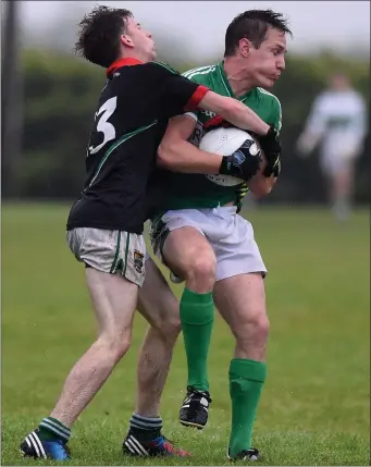  ?? Photo by Michelle Cooper Galvin ?? Denis Sheehan Legion caught in possession by Eoin O’Shea Milltown Castlemain­e in the Kerry County Credit Union league at Milltown on Saturday