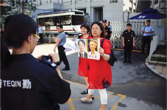  ??  ?? WANG QIAOLING, wife of the lawyer Li Heping, takes part in a protest with other relatives of those detained in what is known as the ‘709’ crackdown in front of the Supreme People’s Procurator­ate in Beijing in July.