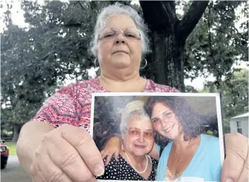  ?? JOSHUA REPLOGLE/THE ASSOCIATED PRESS ?? Susan Bro, the mother of Heather Heyer, holds a photo of Bro’s mother and her daughter, in Charlottes­ville, Va. Heyer was killed Saturday when James Alex Fields Jr. allegedly plowed his car into a group of counter-protesters.