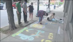  ?? LAUREN HALLIGAN - MEDIANEWS GROUP ?? Artists put the final touches on a sidewalk mural on River Street in downtown Troy for the Troy River Fest Ramble’s Chalk Art Contest.