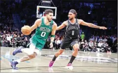  ?? AFP ?? Jayson Tatum (left) of the Boston Celtics drives against Patty Mills of the Brooklyn Nets during Game Three of the Eastern Conference First Round NBA Playoffs.