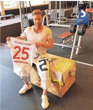  ?? FOTO: PASCAL BIEDENWEG ?? Der Düsseldorf­er Fitnesscoa­ch Dany Petric mit den Trikots seiner Kunden: Fußball-Stars wie Matthias Zimmermann, Sebastian Rudy und Julian Weigl werden von dem 31-Jährigen fit gehalten.