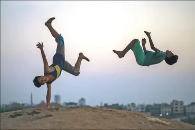  ?? MOHAMMED ABED / AGENCE FRANCE-PRESSE ?? Palestinia­n youths momentaril­y defy gravity in Gaza city.