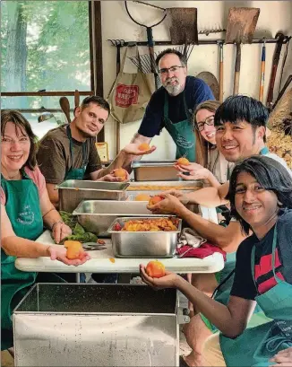  ?? CONTRIBUTE­D PHOTOS BY ASHA GOMEZ ?? The kitchen crew pauses during a peach-canning session at the home of Bernie Wong in Carrollton, Georgia. “Every year, nine families in this Georgia town pool their resources to buy 750 pounds of the freshest peaches,” writes Asha Gomez. “For an entire week, one of their homes becomes a production facility, resulting in peach jam, peach barbecue sauce, peach chutney, peach pie filling and peach preserves.”