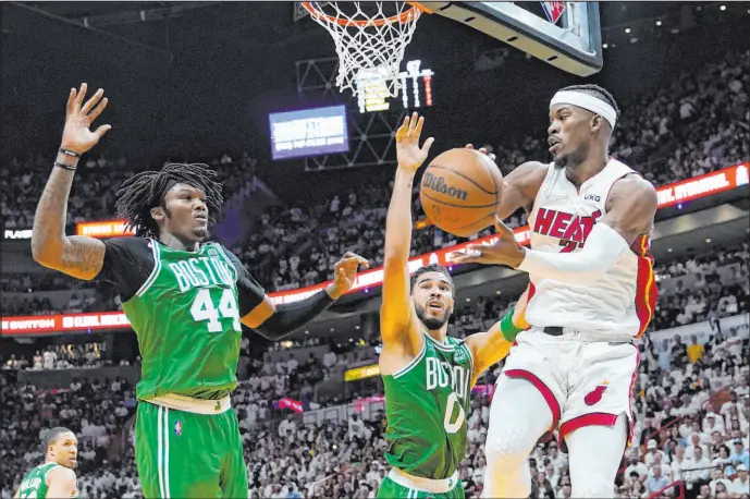  ?? Lynne Sladky The Associated Press ?? Boston Celtics center Robert Williams III (44) and forward Jayson Tatum close in on Miami Heat forward Jimmy Butler during Game 1, when Butler had 41 points.