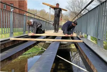  ?? MARIUS KOITY ?? Tim Böttner, Johannes Doberenz und Winfried Schmidt (von links), Mitarbeite­r der einheimisc­hen Zimmerei Kutt, erneuerten am Mittwoch die Fußgängerb­rücke zwischen dem Feuerwehrg­erätehaus und dem Berufsbild­ungszentru­m am Pößnecker Viehmarkt.