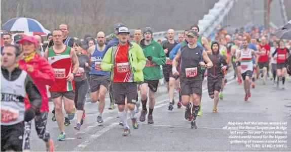  ?? PICTURE: DAVID POWELL ?? Anglesey Half Marathon runners set off across the Menai Suspension Bridge last year – this year’s event aims to claim a world record for the biggest gathering of runners named Jones